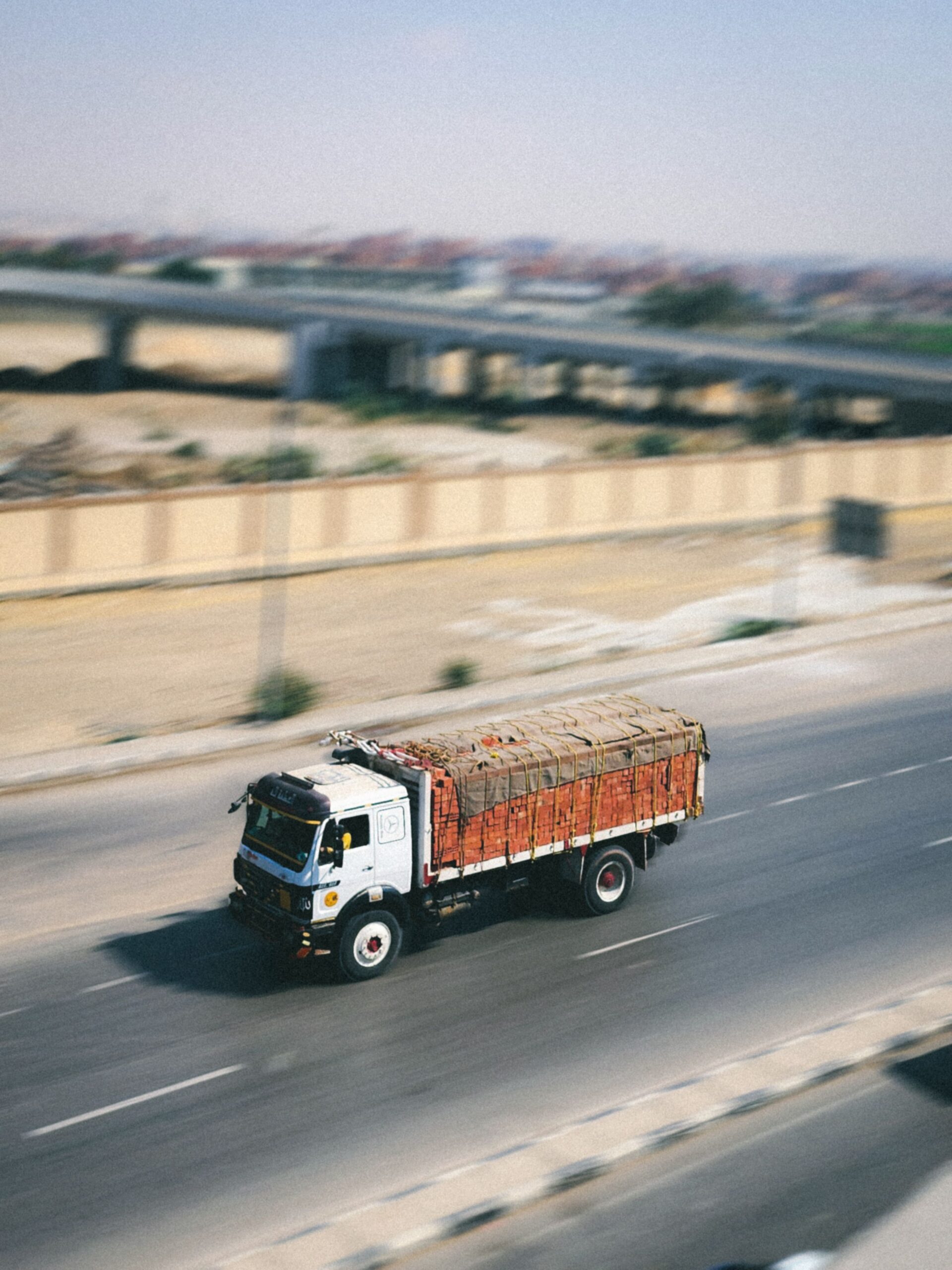 Home A cargo truck swiftly travels on a highway, emphasizing logistics and speed.